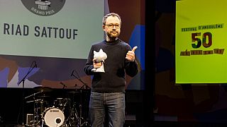 French comics writer Riad Sattouf poses on stage after receiving the 'Grand Prix' for his all work during the 50th Angouleme International Comics Festival 