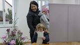 A child casts her mother's ballot at the presidential elections runoff in Pruhonice, Czech Republic.