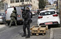 An Israeli policeman secures a shooting attack site in east Jerusalem, 28 January 2023