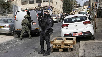 An Israeli policeman secures a shooting attack site in east Jerusalem, 28 January 2023