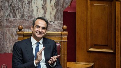Greek Prime Minister Kyriakos Mitsotakis claps during a parliamentary debate on a motion of censure in Athens, on Friday, Jan. 27, 2023