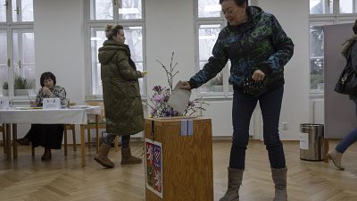 A woman votes at the presidential elections runoff at a polling station in Pruhonice, Czech Republic.
