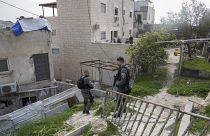 Israeli paramilitary border police stand next to the family home of a Palestinian gunman who killed several people.