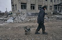 A local resident walks along a street after the heaviest battles with the Russian invaders in Bakhmut, Ukraine, Thursday, Jan. 12, 2023. (AP Photo/LIBKOS)