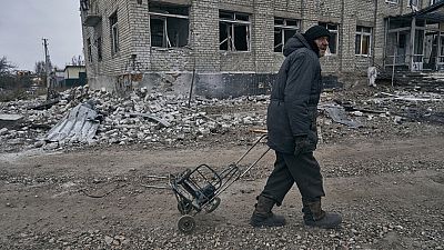 A local resident walks along a street after the heaviest battles with the Russian invaders in Bakhmut, Ukraine, Thursday, Jan. 12, 2023. (AP Photo/LIBKOS)