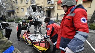 Médicos ucranianos llevan el cuerpo de un residente local muerto en un edificio residencial tras un bombardeo ruso en Jersón, sur de Ucrania.