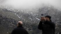 La gente toma fotos en el paisaje natural de la Serra de Tramuntana cubierto de nieve después de la última nevada en Palma de Mallorca, España, el jueves 26 de enero de 2023.