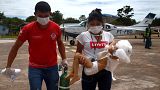 Profissional de saúde carrega criança Yanomami transportada de avião para Boa Vista, Roraima