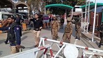 Army soldiers and police officers clear the way for ambulances rushing toward a bomb explosion site, at the main entry gate of police offices, in Peshawar, Pakistan, Monday, J
