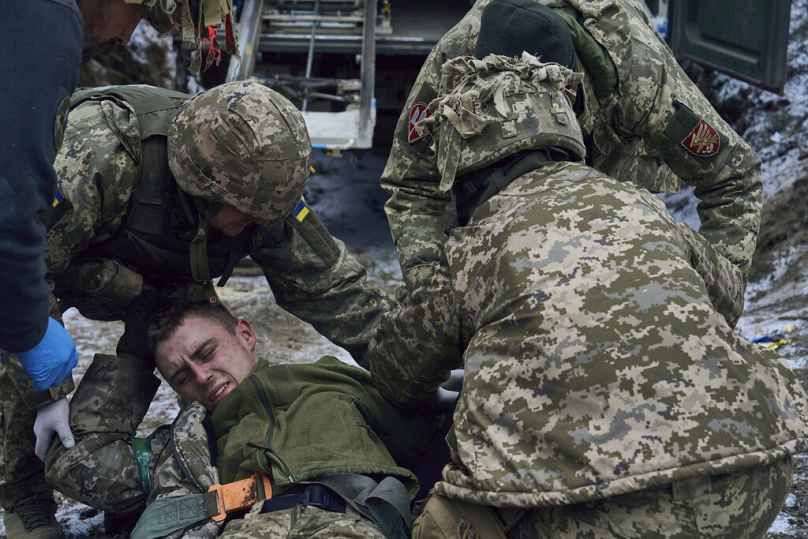 Military medics give first aid to a wounded soldier near Kremenna in the Luhansk region, Ukraine, Monday, Jan. 16, 2023