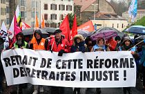 متظاهرون من النقابات يحملون لافتة كتب عليها "اسحبوا هذا الإصلاح غير العادل للمعاشات التقاعدية" خلال مظاهرة في بايون، جنوب غرب فرنسا.
