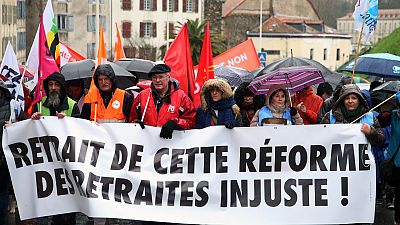 متظاهرون من النقابات يحملون لافتة كتب عليها "اسحبوا هذا الإصلاح غير العادل للمعاشات التقاعدية" خلال مظاهرة في بايون، جنوب غرب فرنسا.