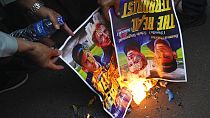 Muslim protesters burn posters during a rally outside the Swedish Embassy in Jakarta, Indonesia, Monday, Jan. 30, 2023.
