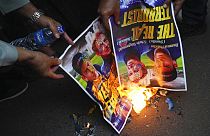Muslim protesters burn posters during a rally outside the Swedish Embassy in Jakarta, Indonesia, Monday, Jan. 30, 2023.