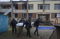 Des employés municipaux transportent des corps de victimes d'un accident d'hélicoptère depuis un jardin d'enfants à Brovary, près de Kyiv