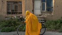 أفغانية على دراجة أمام بيتها في كابول اعتراضاً على منع النساء من المشاركة في النشاطات الرياضية 