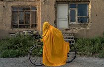 أفغانية على دراجة أمام بيتها في كابول اعتراضاً على منع النساء من المشاركة في النشاطات الرياضية 