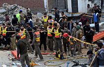 مقامات امنیتی و نیروهای امدادی در محل حمله انتحاری، در پیشاور پاکستان