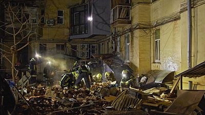 Tűzoltók egy orosz találatot kapott lakóház romjai között Harkivban