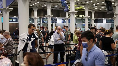 People queue to check in for the Eurostar rail service at St Pancras International Station in London, Britain, July 25, 2022.