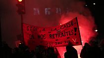 Protesters hold a banner demanding to stop plans to push back France's retirement age, during a demonstration against Tuesday, Jan. 31, 2023 in Paris.