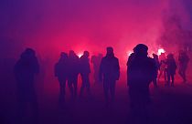 Demonstrators walk through flare smoke during a demonstration against plans to push back France's retirement age,Jan. 31, 2023 in Paris. 