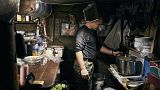 Ein ukrainischer Soldat kocht in einem Luftschutzkeller in Bachmut