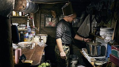 Ein ukrainischer Soldat kocht in einem Luftschutzkeller in Bachmut