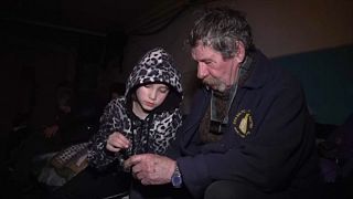 Egy kislány a nagypapájával egy bahmuti pincében.