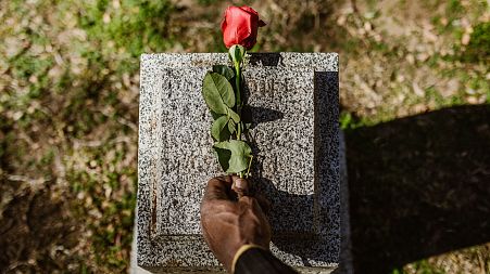 A rose is placed on a gravestone
