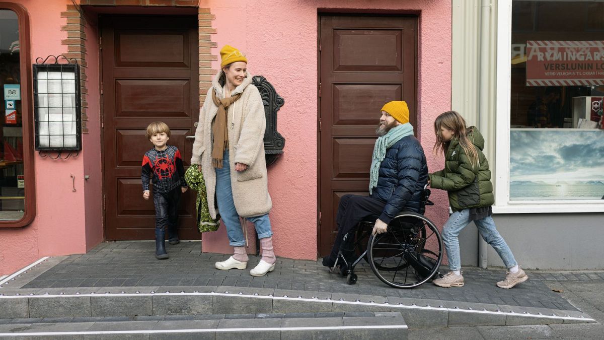 Haraldur Þorleifsson using an accessible ramp whilst on a walk with his family.