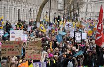 Thousands of demonstrators wave banners as they stand near Downing Street in Westminster, London.