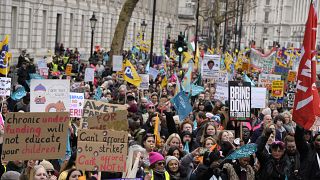 Thousands of demonstrators wave banners as they stand near Downing Street in Westminster, London.