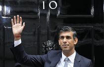 British Prime Minister Rishi Sunak waves after arriving at Downing Street in London
