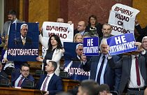 "Nem az ultimátumra!" és "Vučić, elárultad Koszovót" feliratú táblák a szerb parlament rendkívüli ülésén 2023. február 2-án