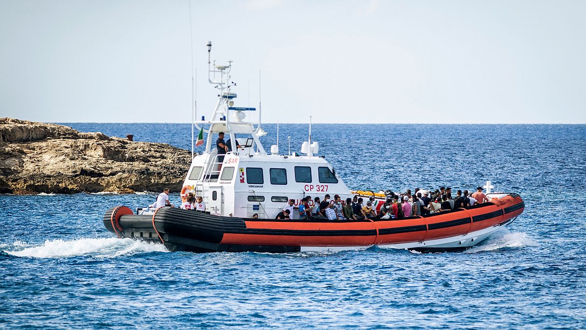 سفينة تابعة لخفر السواحل الإيطالي وهي تقل عددا من المهاجرين في جنوب إيطاليا