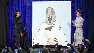 Amy Sherald (R) unveils her portrait of Michelle Obama with the former First Lady herself