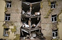 Des débris sont suspendus à un immeuble résidentiel fortement endommagé lors d'un bombardement russe à Bakhmut, dans l'est de l'Ukraine, dans l'est de l'Ukraine