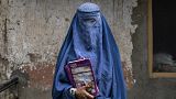 Afgán nő egy illegálisan működő iskola előtt