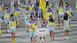 Olena Kostevych and Bogdan Nikishin carry Ukraine's flag during the opening ceremony in the Olympic Stadium at the 2020 Summer Olympics in 2021.