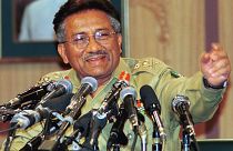 Musharraf spricht in zahlreiche Mikrofone.