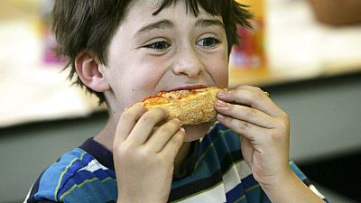 ABD'de bir okulda yıl sonu partisinde pizza yiyen 7 yaşındaki Henry Wineman isimli öğrenci (arşiv)