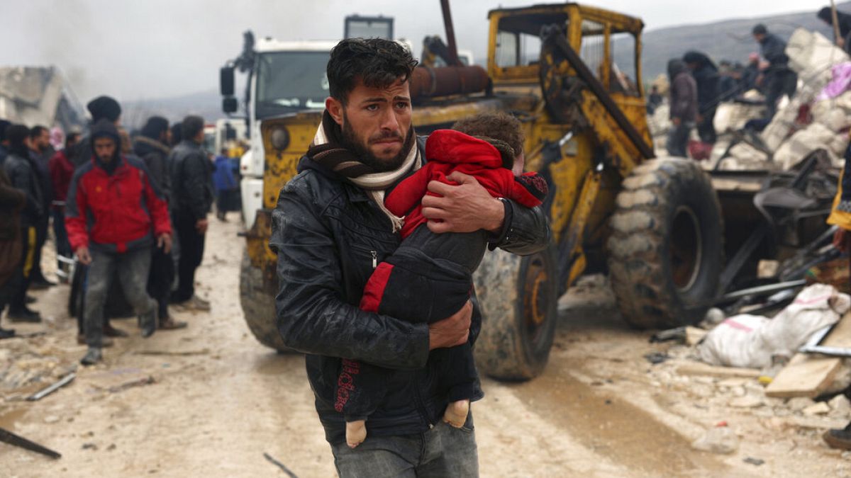 Férfi a gyermekével a földrengést követően a dél-törökországi Kahramanmaras tartományban, Pazarcikban 2023. február 6-án.