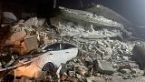 Carro soterrado pelos destrroços de um edifício destruído pelo sismo em Idlib, na Síria