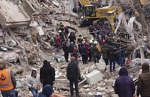 Des secouristes et équipes médicales tentent d'atteindre les résidents piégés dans un bâtiment effondré à la suite à Diyarbakir, le 6 février 2023.