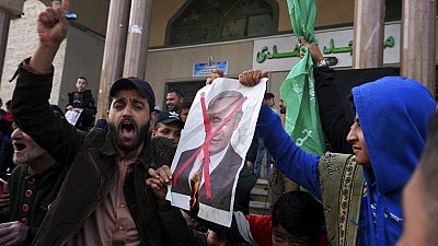 Simpatizantes de Hamás y la Yihad Islámica corean consignas mientras queman una foto del primer ministro israelí, Benjamin Netanyahu. 