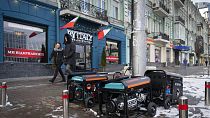 People pass by working generators during a power outage in Kyiv, Ukraine, Monday, Feb. 6, 2023.
