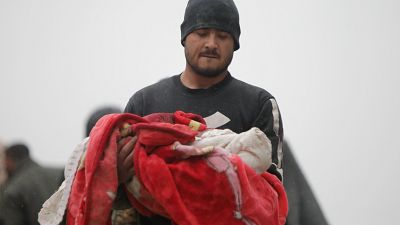 رجل سوري يحمل جثة رضيع قُتل إثر زلزال وقع في بلدة جندريس بريف مدينة عفرين شمال غرب سوريا في الجزء الخاضع لسيطرة الثوار من محافظة حلب، في 6 شباط/فبراير 2023.