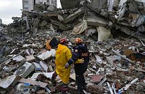 Emergency team members pause for a moment as they search for people in a destroyed building in Adana, Turkey, Monday, Feb. 6, 2023