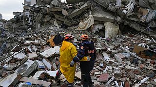 Emergency team members pause for a moment as they search for people in a destroyed building in Adana, Turkey, Monday, Feb. 6, 2023